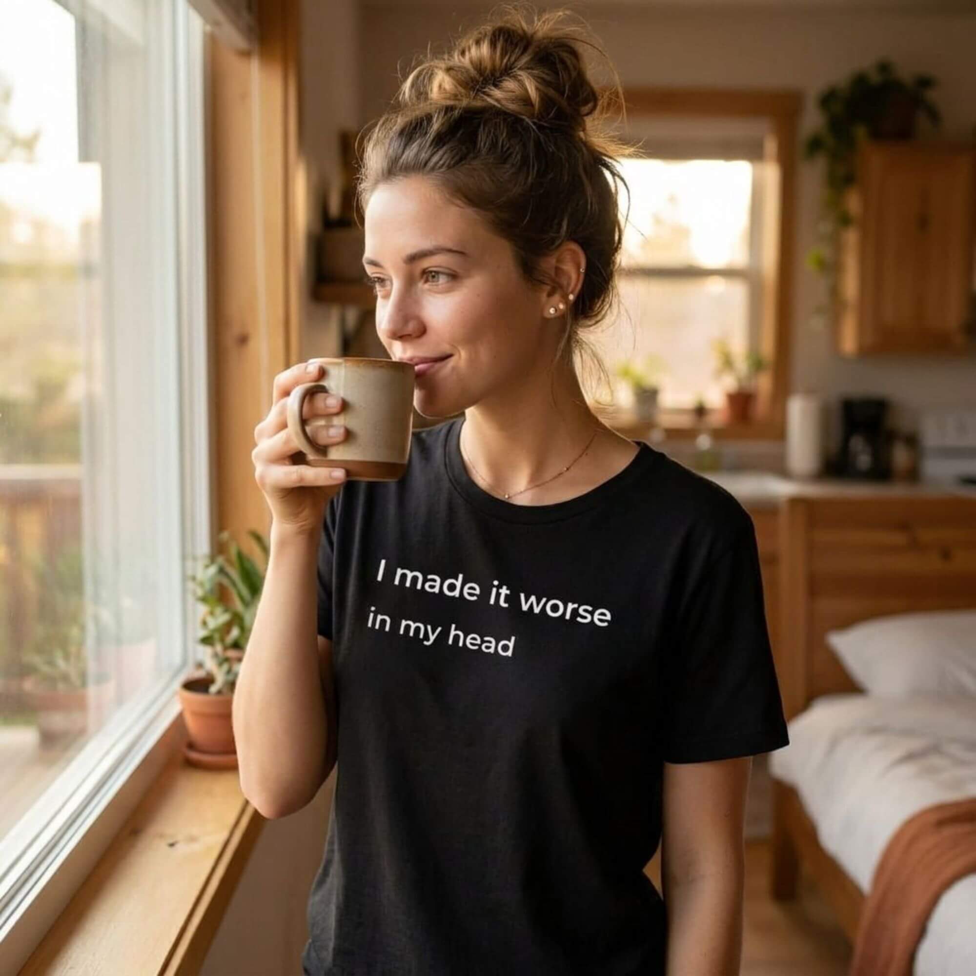 woman in i made it worse in my head black tee holding coffee — warm light — text & tone