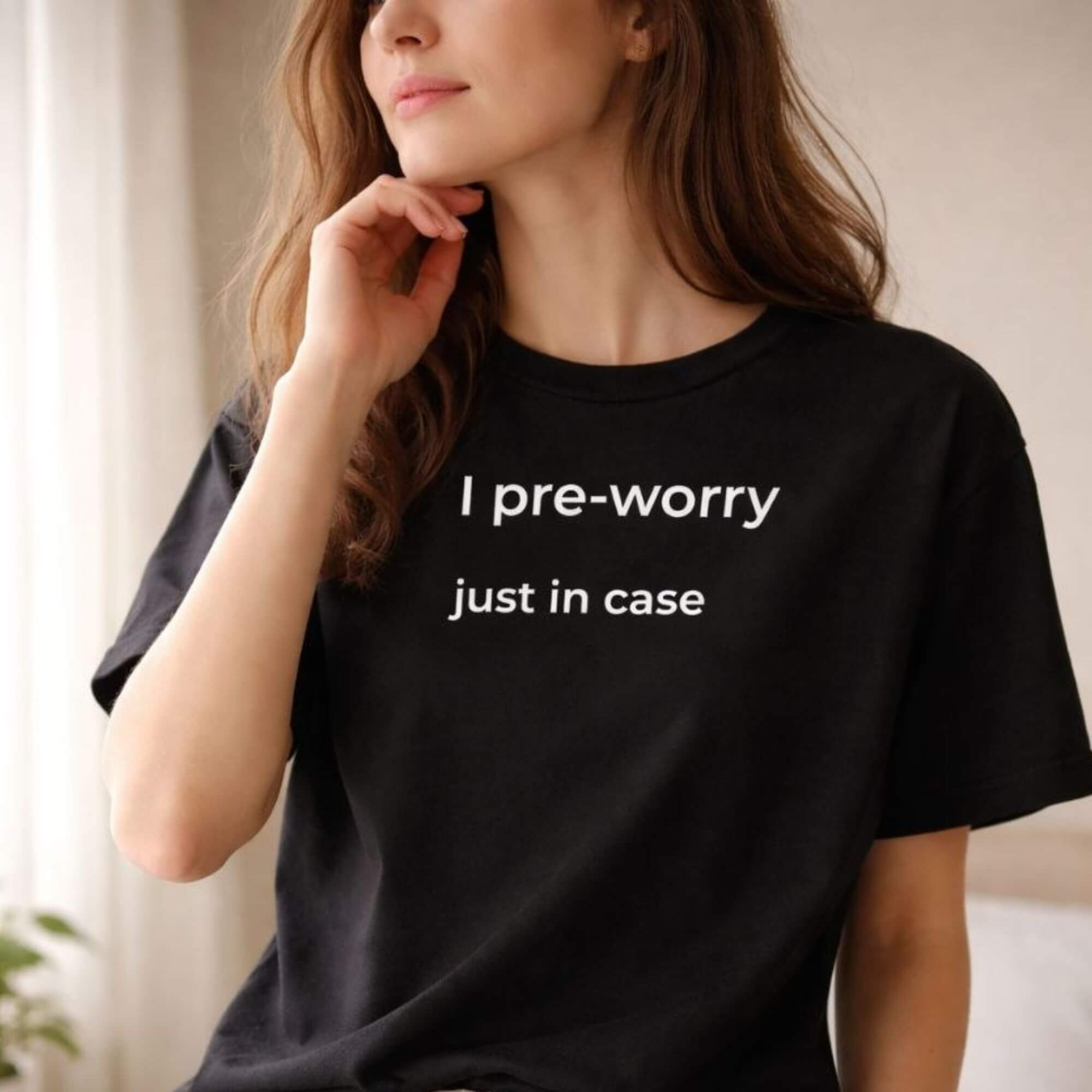 Woman wearing black minimalist T-shirt with "I pre-worry just in case" print