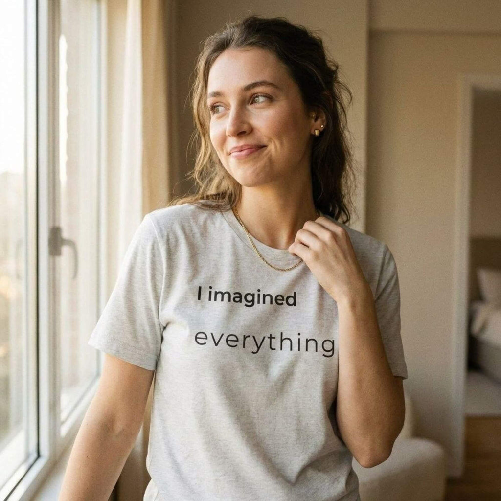 woman in i imagined everything cream tee smiling — soft natural light — text & tone
