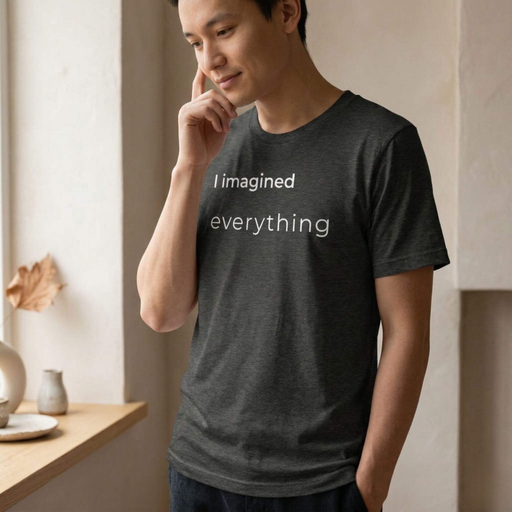 Man wearing dark minimalist T-shirt with "I imagined everything" text