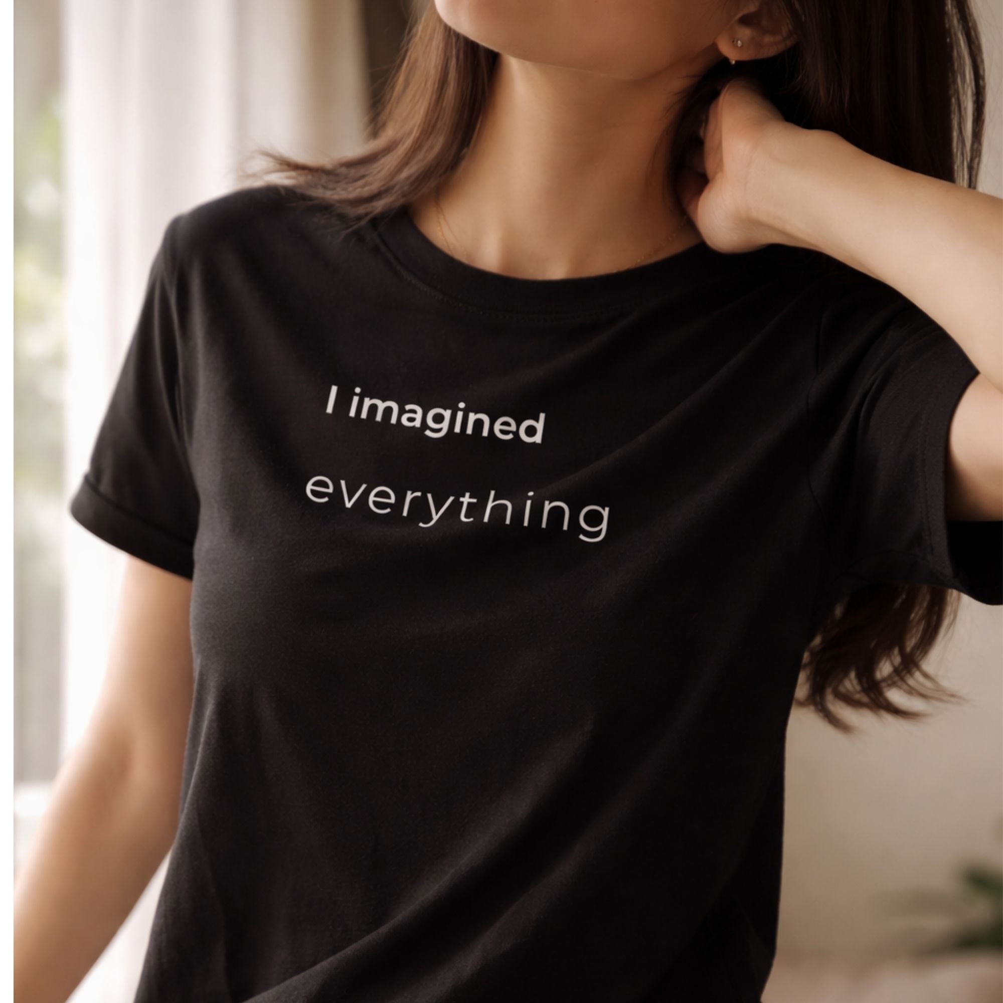 Woman wearing black minimalist T-shirt with "I imagined everything" print